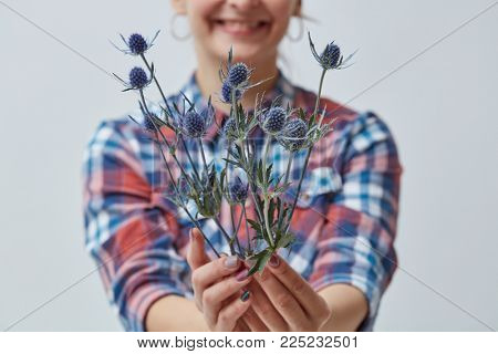 Young girl holding a blue flower