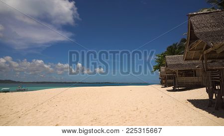 Beach with white sand with beach house on a tropical island Daco. Beautiful sky, sea, resort. Seascape: Ocean and beautiful beach paradise. Philippines. Travel concept.