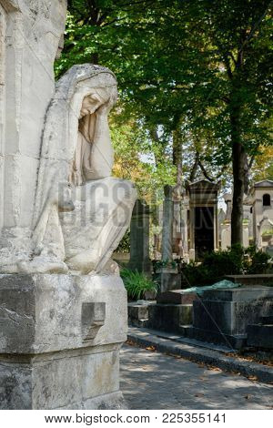 Beautiful statue of a sad woman on the Pere Lachaise cemetery in Paris