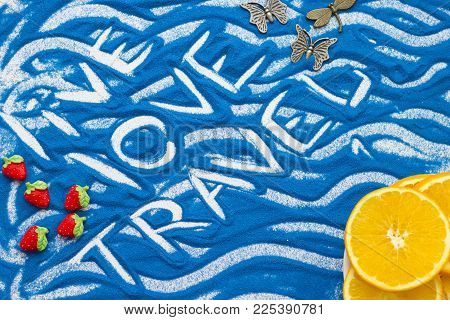 Live Love Travel Inscription On A Blue Colored Sand With Waves, Slices Of Fresh Orange And Decoratio