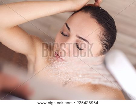 Young beautyful woman under shower in bathroom.