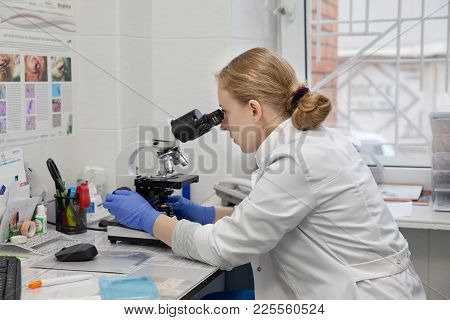 Doctor Woman Working With A Microscope In Laboratory. Female Scientist Looking Through A Microscope 