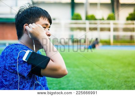 Sport Man Is Sitting And Listening His Favorite Song By Smart Pohne That Hold On His Arm During Rela