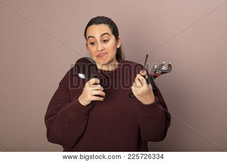 Hopeless Diy Ethusiast Woman As She Holds A Spanner, A Hammer And Manifying Glass In Her Hands