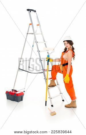 Beautiful Workwoman Holding Painting Roller Near Ladder And Toolbox, Isolated On White