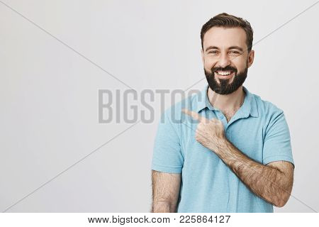 Middle Aged Man With A Happy Smile Pointing Away Over White Background. Handsome Bearded Guy Just Sa