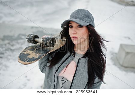 Stylish Brunette Girl In Gray Cap, Casual Street Style With Skate Board On Winter Day.