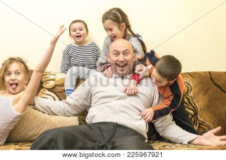 Happy Dad With Four Young Children. Two Girls And Two Boys. Selected Focus