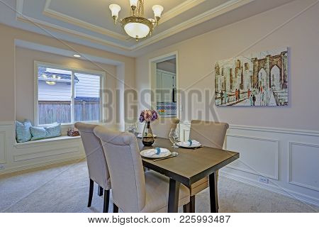 Chic Dining Room Accented With Wall Panel Mouldings And Tray Ceiling.