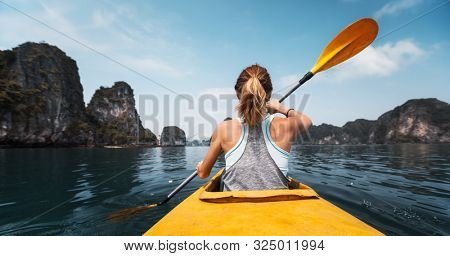 Woman paddles kayak in the Ha Long Bay in Vietnam