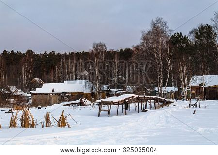 Old Wooden Pier In The Snow. Wooden House At The Frozen Lake. Countryside