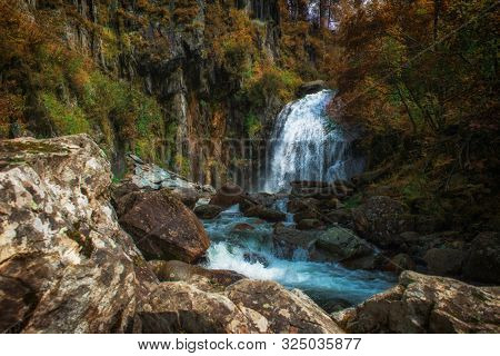 Korbu Waterfall at Lake Teletskoye in autumn Altai Mountains. The most famous lake waterfall