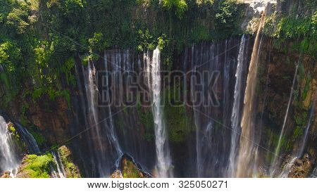 Aerial View Waterfall Coban Sewu In Java, Indonesia. Waterfall In Tropical Forest By Drone Tumpak Se