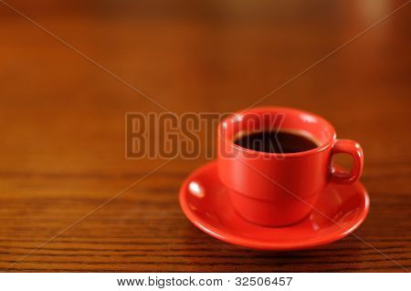 Tazza di caffè rosso sul tavolo di legno