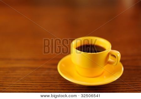 Giallo tazza di caffè sul tavolo di legno