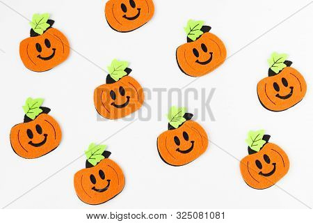 Top View Of Halloween Crafts, Felt Handmade Pumpkins On White Paper Background . Halloween Concept. 