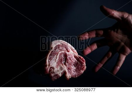 Man Hand And Piece Redraw Pork Neck Meat On Dark Background