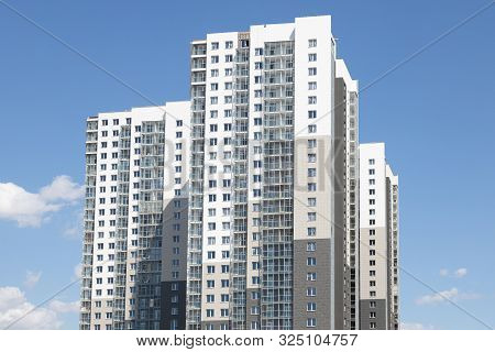 High White-grey Multi-family Dwelling Building Against Blue Sky In Daylight