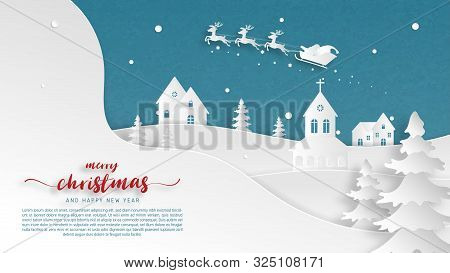 Winter Landscape With Santa Claus On Sleigh And Reindeer Flying Over Village On Snowfield In Paper C