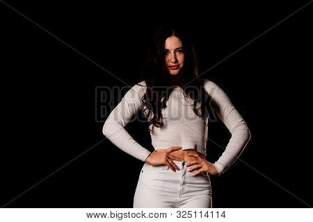 Young Lady With Hair In Topknot Standing With Arms Folded Looking Up. Capricious Female Model In Gre
