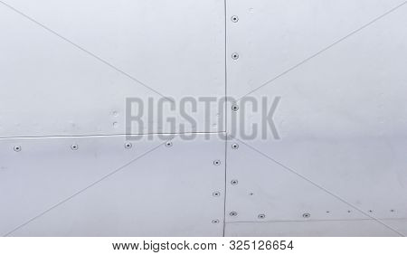 Silver Metal Surface Of The Aircraft Fuselage With Rivets. Fuselage Detail View. Airplane Metallic F