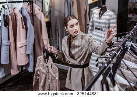 Young Fashionista Looking For Overclothes On Her Shopping