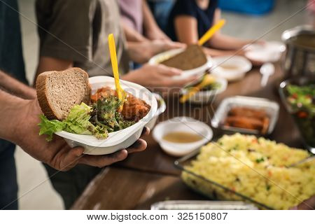 Poor Man Holding Plate With Food In Charity Centre, Closeup