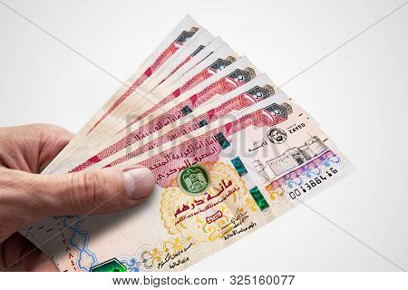 Hand Holding Dirhams Of United Arab Emiratess. Aed. Currency Of Uae.