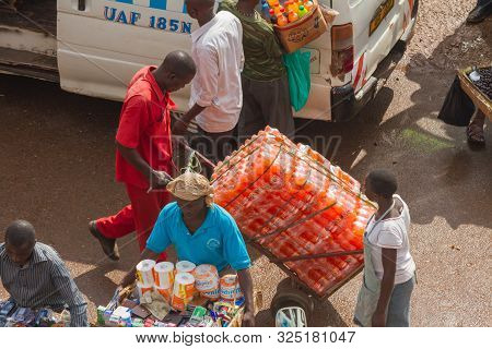 Kampala, Uganda - October 03, 2012.  An African Man Moves Cases Of Soda Pop Across The Taxi Park In 