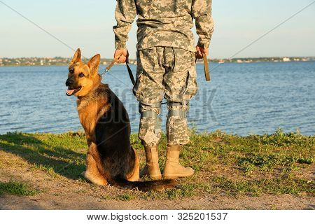 Man In Military Uniform With German Shepherd Dog Outdoors, Closeup