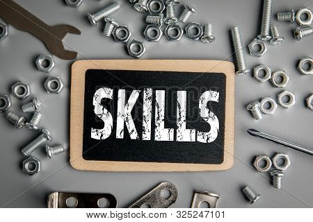 Skills Concept. Metal Bolts And Nuts In A Gray Background. Chromed Screw Bolts And Nuts. Set Of Nuts