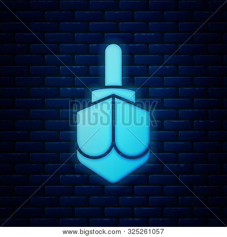 Glowing Neon Hanukkah Dreidel Icon Isolated On Brick Wall Background. Vector Illustration