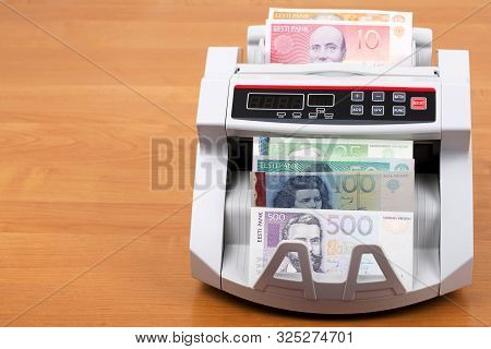 Estonian Kroon In A Counting Machine On A Wooden Background