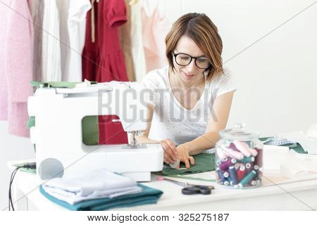 Young Pretty Girl Student Study At A Clothes Designer In College And Does Her First Thesis Sitting A