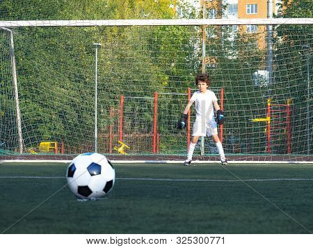 Young Goalkeeper On An Outdoor Court Standing In The Football Gate. Football, Soccer Player. Goalkee