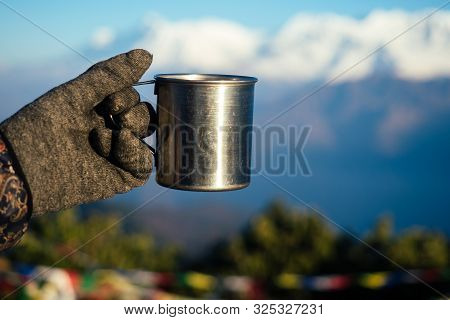 A Metal Cup With A Hot Drink In The Hand Against The Background Of The Mountains. The Concept Of An 