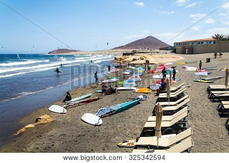 El Medano, Spain - July 7 2019: People Surfing, Kiting And Windsurfing On Playa De Leocadio Machado