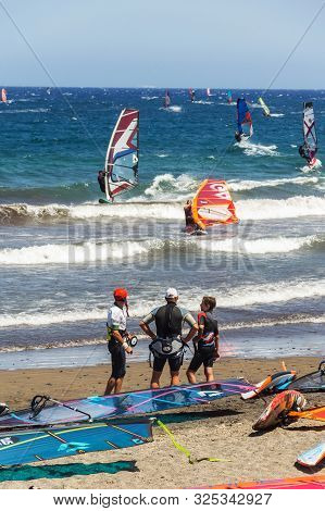 El Medano, Spain - July 7 2019: People Surfing, Kiting And Windsurfing On Playa De Leocadio Machado