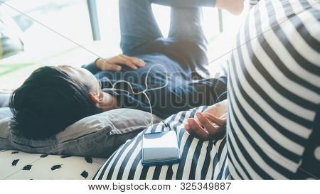 Young Man Relaxing Listening The Music From Mobile Phone.