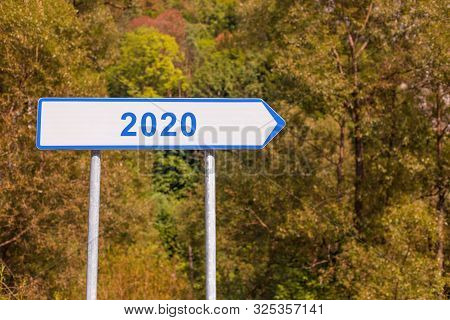 2020 Happy New Year - Signpost. White Waywiser Sign Showing Direction To Year 2020. Nature Backgroun