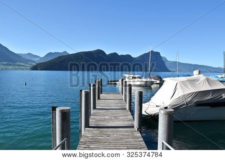 Vitznau, Switzerland 29.09.2019: A Walk On A Pier With A View Of Lake Lucerne And Sailing Boats Arou