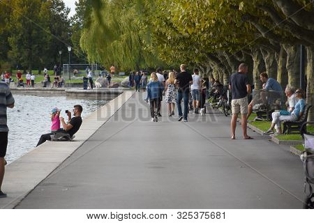Zug, Switzerland 29.09.2019: A Father Is Playing With His Daughter And People Walking, Relaxing On B
