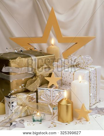 A Layout Of Holiday Gifts With Candles And Stars