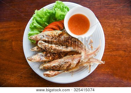 Fried Fish With Vegetable Salad Tomato And Sauce On White Plate Wooden Table / Freshwater Fish Mekon