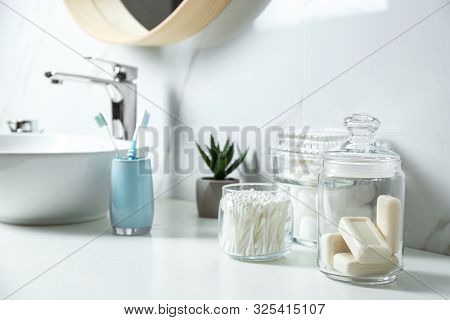 Cotton Swabs And Soap Bars On White Countertop In Bathroom
