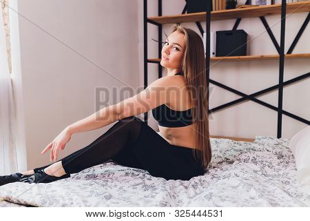 Attrctive Fitness Woman Doing Stretching Exercises At Home, As Part Of A Healthy Lifestyle Without G