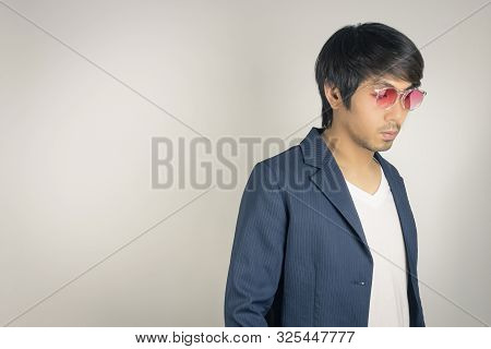 Portrait Asian Casual Businessman In Navy Blue Suit Wear Red Eyeglasses At Right Frame On Grey Backg