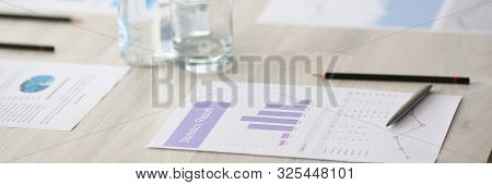 Silver Pen With Business Chart And Drink Water On Seminar Table. Financial Education Concept