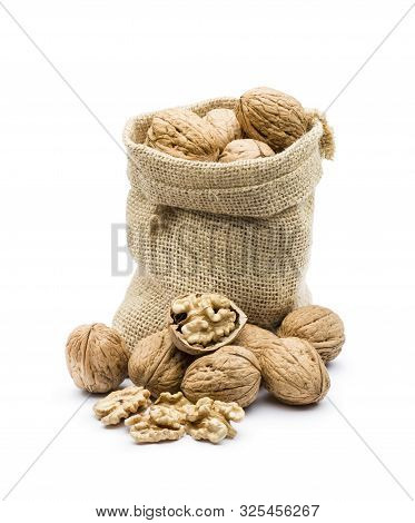 Pile Of Walnuts In Juta Bag On White Background