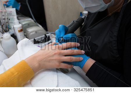 Close-up Of Professional Finger Nail Treatment, Grinding And Polishing With Electric Nail File Drill